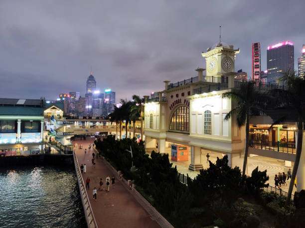 People walking on the waterfront at night by the historical Central Pier in Hong Kong island