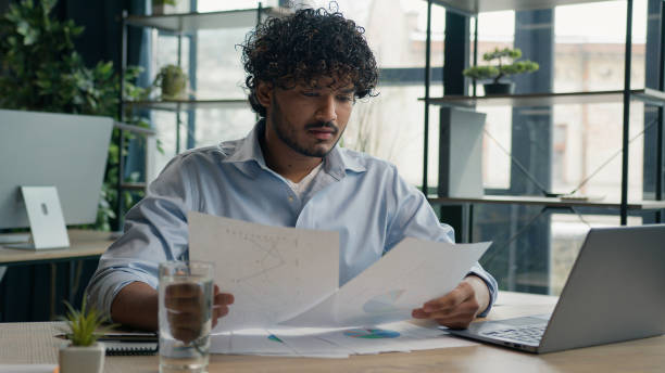 istock Focused businessman business person accountant office worker writing ideas in notebook paperwork Arabian Indian student write notes data information e-learning with laptop computer educational course 2195307976