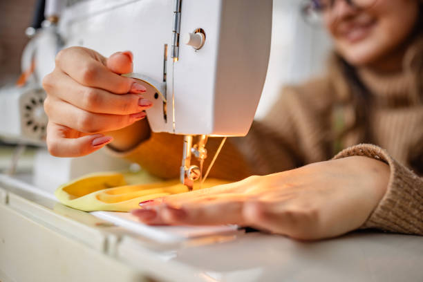 istock Woman sewing fabric with a sewing machine in a cozy indoor space during daylight hours 2195308876