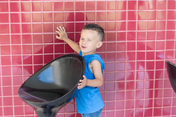 boy in blue standing on chair with red background
