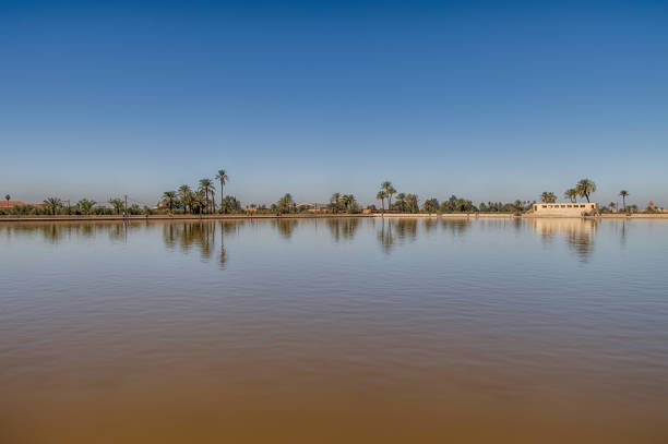 Menara gardens reflecting pool and pavilion with the snow capped Atlas mountains in the background, Marrakech, Morocco.