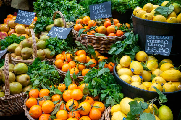 Fruit on a greengrocer’s stall in Borough Market, Southwark, London - apples, pears, oranges and lemons.