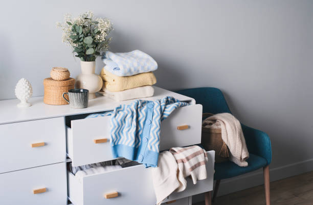 istock white scandi drawer with messy knitted sweaters. Spring home cleaning and wardrobe organization. Sorting clothes. 2195321856