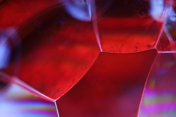 Red liquid surface in the darkness, bright fluid background, smooth movement, rainbow reflection