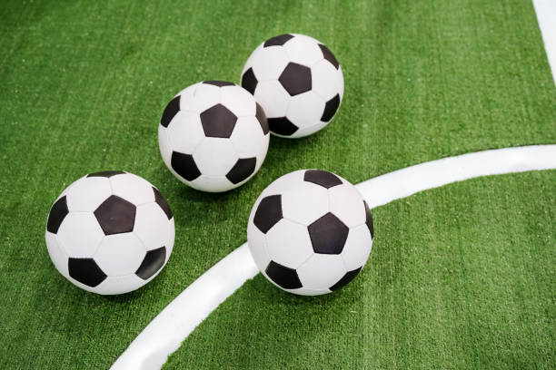 istock Three brightly colored soccer balls are resting peacefully on a vast, lush green field under the blue sky, ready for a game of soccer, a beloved sport enjoyed by many around the world 2195328489