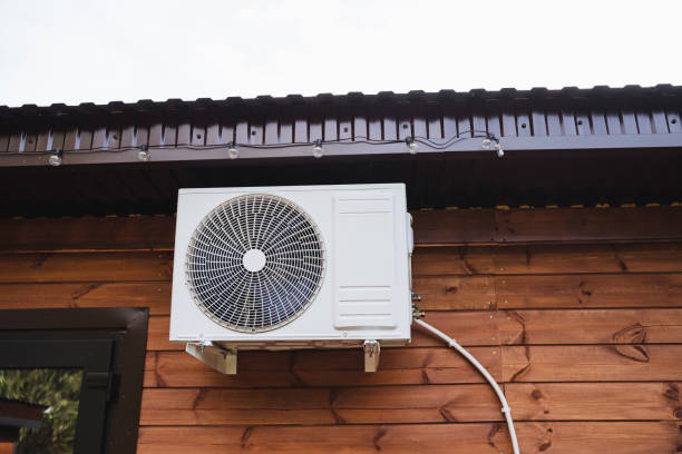 istock A white air conditioner is firmly mounted on a sturdy wooden building, blending functionality and aesthetic appeal with the surrounding rustic environment for a harmonious look 2195328601