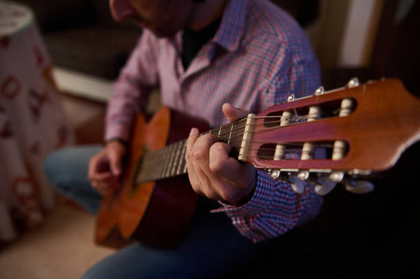 istock Man Playing Guitar in a Cozy Room 2195329074