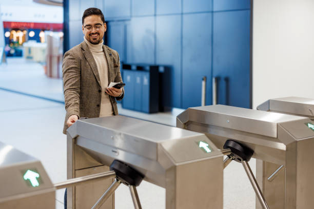 istock Businessman using smartphone and opening turnstile gate in modern office building 2195331041