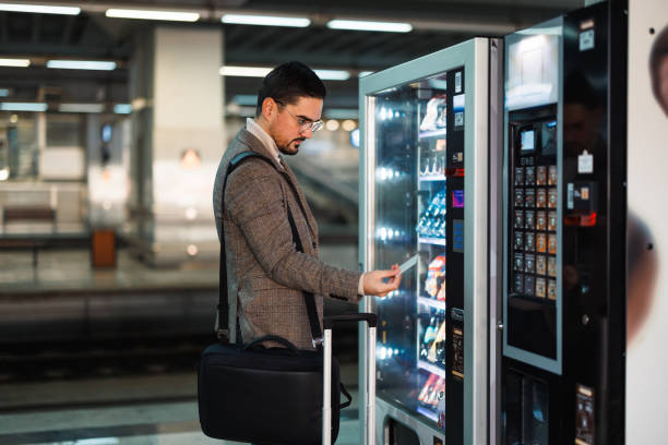 istock Businessman buying snacks at vending machine in train station 2195331142