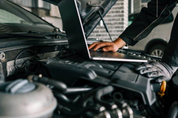 istock A mechanic using a laptop on a car engine for diagnostics in a garage. Highlights the use of technology in modern vehicle maintenance and repair 2195332615