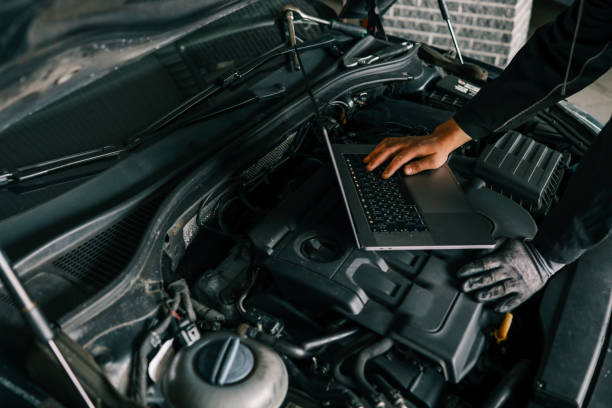 istock A mechanic using a laptop on a car engine for diagnostics in a garage. Highlights the use of technology in modern vehicle maintenance and repair 2195332618