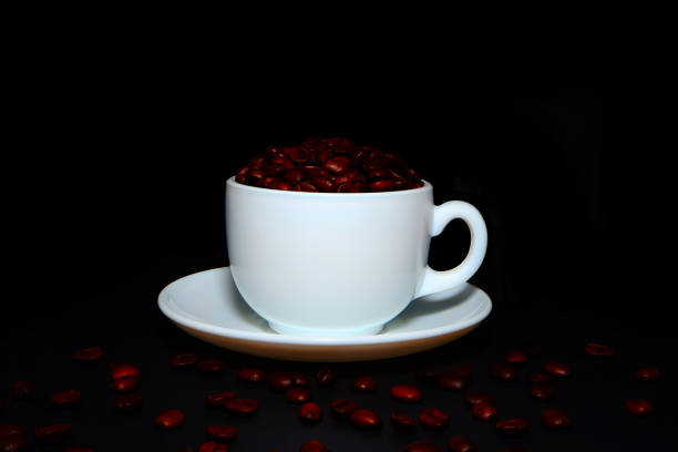 Cup and saucer with coffee beans close-up view concept background