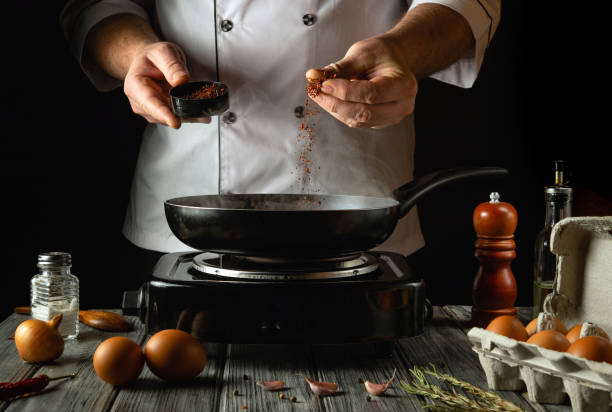 istock A skilled cook prepares a delicious meal by adding spices to a sizzling pan. Fresh eggs and ingredients adorn the rustic kitchen counter, creating an inviting atmosphere for culinary exploration 2195335499