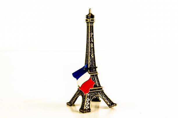 A small model of the Eiffel Tower with a flag on top. The flag is red, white, and blue
