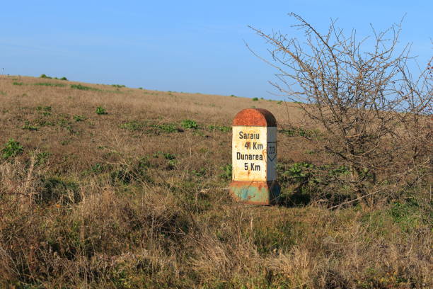 istock Old kilometer marker in open, dry, field 2195338276
