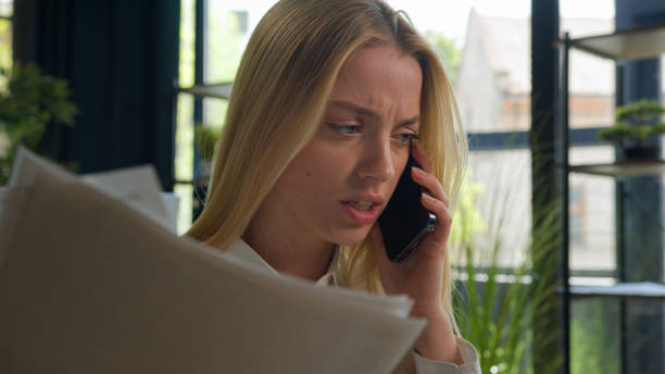 istock Caucasian businesswoman talk mobile phone arguing negative emotion dissatisfied wrong business contract financial report documents mistake stressed angry entrepreneur girl woman call smartphone shout 2195339501