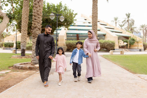 istock Arab family walking in a park together on a weekend 2195339552