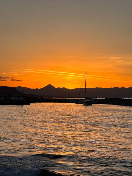 istock A beautiful sunset shining over the mountains with a sail boat 2195342896