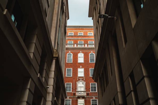 Low angle view of a red brick building between two grey buildings in london, uk