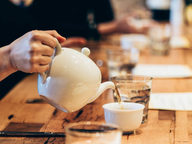 istock Pouring Tea From White Teapot in Restaurant 2195344634