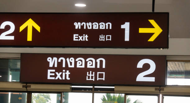 istock Directional signs guide travelers to exit points at a bustling airport terminal in Thailand 2195345406