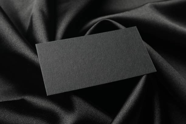 istock Blank business card on black fabric, closeup. Mockup for design 2195349826