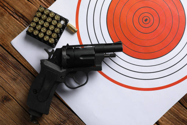 istock Shooting target, handgun and bullets on wooden table, top view 2195351785