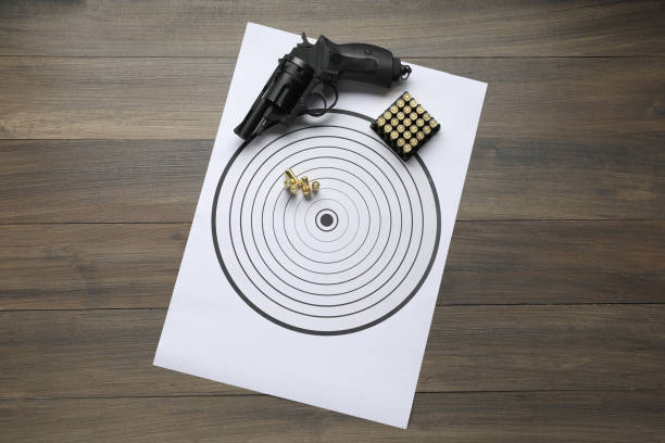 istock Shooting target, handgun and bullets on wooden table, top view 2195351802