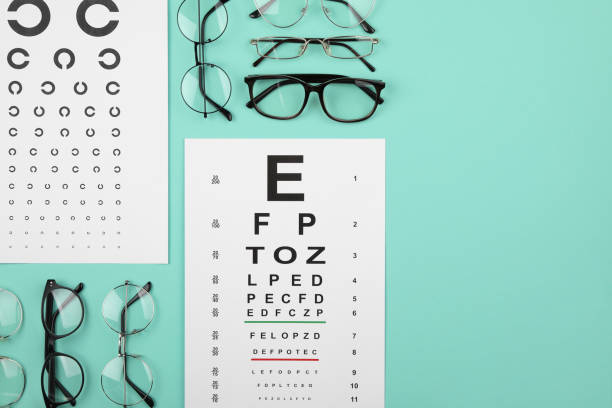 istock Vision test chart and glasses on turquoise background, flat lay. Space for text 2195355479