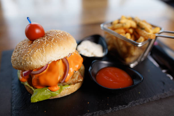 istock Delicious Cheeseburger With Crispy Fries and Sauces on Slate Platter 2195355802