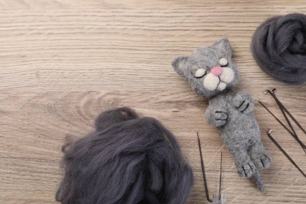 istock Felted cat, wool and tools on wooden table, flat lay. Space for text 2195356152