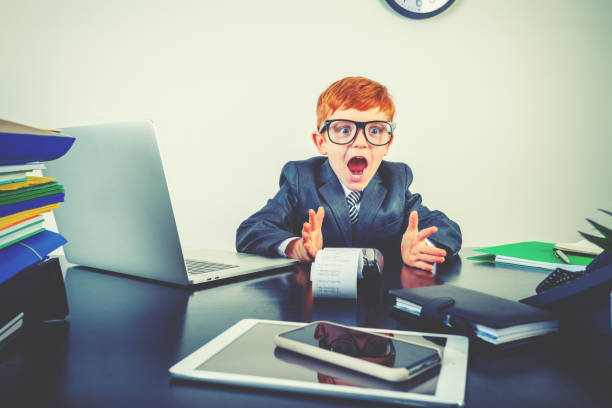 istock Humorous image of surprised young boy working at a desk 2195358819
