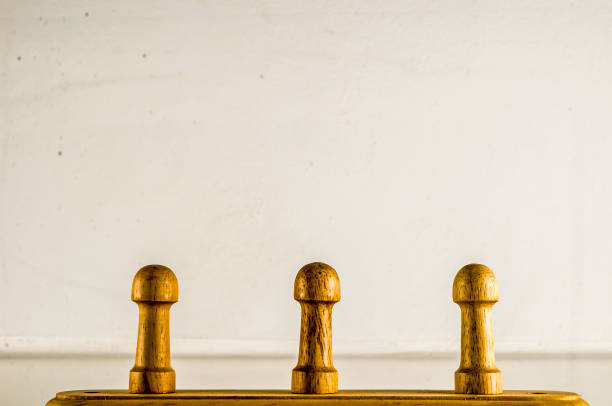 istock Three wooden pegs are standing on a white wall 2195358901