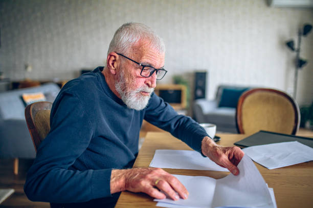 istock Senior man is sorting out his paperwork at home 2195360895