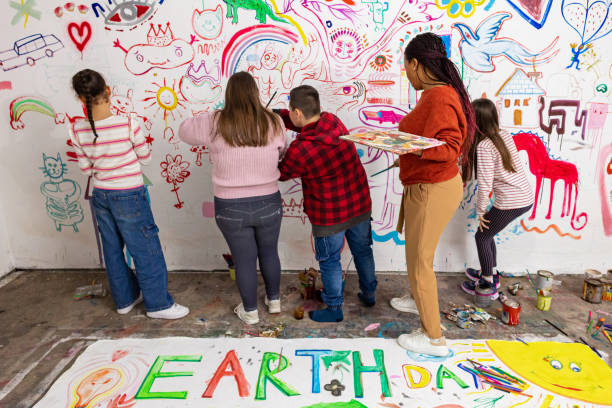 Teacher Helps Kids Paint Classroom Wall