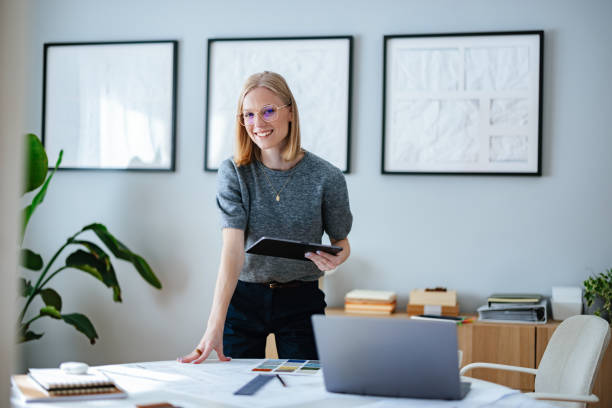 istock Professional Interior Designer Working in Stylish Home Studio with Tablet and Plans 2195365598