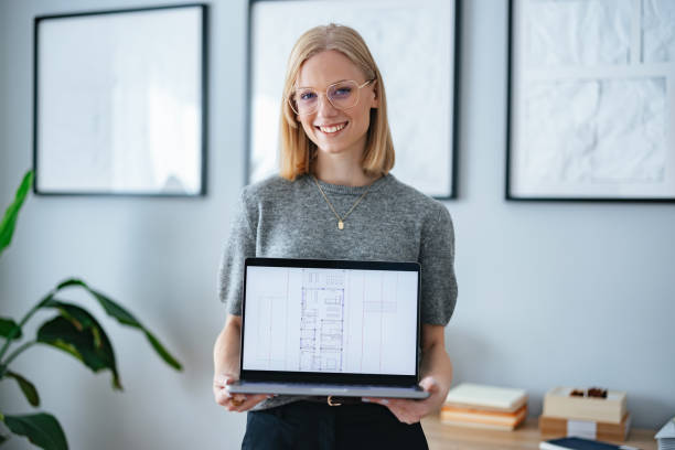 istock Architect Presenting Floor Plan on Laptop in Modern Home Office Setting 2195365602