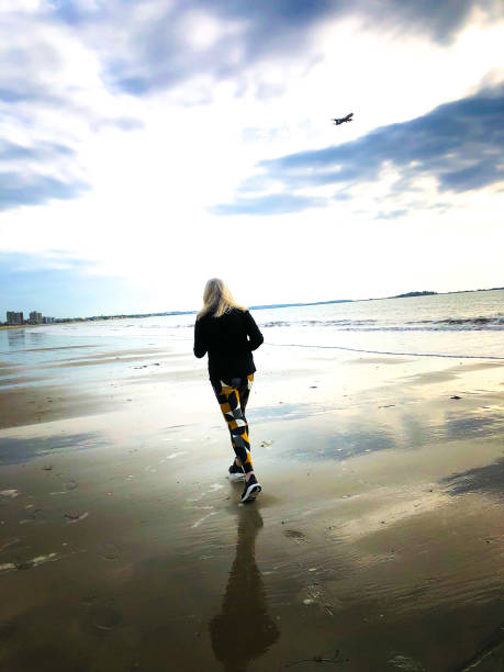 istock Active Senior Woman Jogging on Beach 2195371480