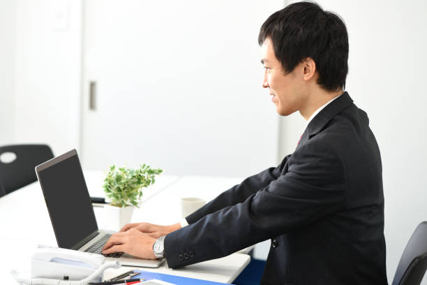 istock An Asian man wearing a suit is operating a laptop while sitting at a desk 2195372720