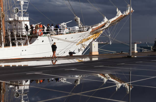 Greenock, Scotland, UK - 9th July, 2011: Four young sailors stowing a sail onto a yard of the Colombian Tall Ship ARC Gloria after the first leg, from Waterford to Greenock, of the Tall Ships Race 2011. The ARC Gloria is a a training ship owned and operated by the Colombian government.