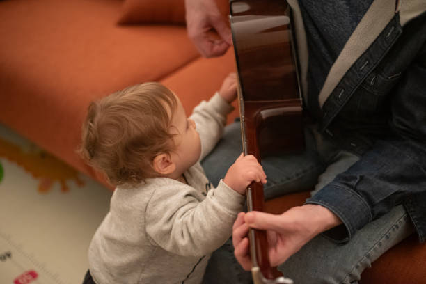 istock Baby playing guitar with his dad 2195374755