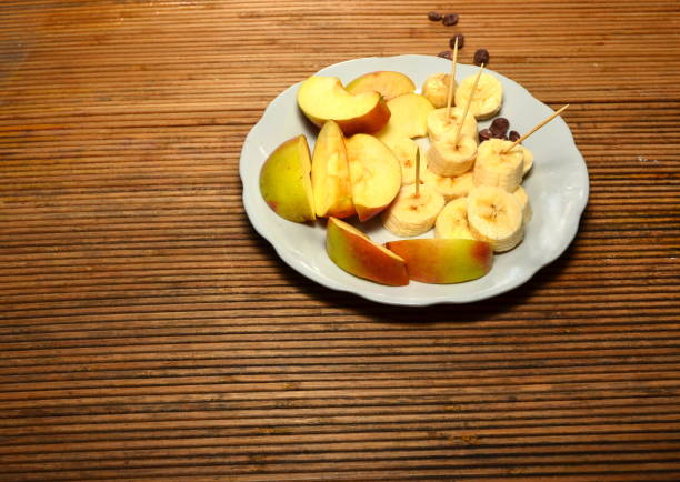 Ripe organic red apple and cinnamon stick on white table background.