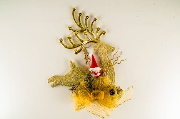 istock A gold colored reindeer with a red hat 2195383766
