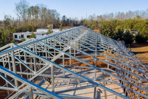 istock Construction of a metal structure progresses under clear skies in a rural area with trees in the background 2195393964
