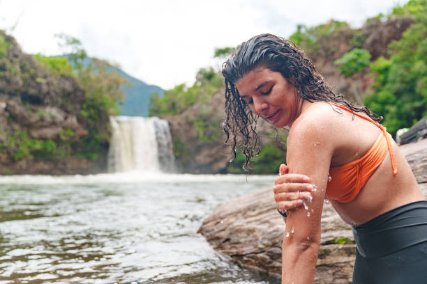 istock Young woman refreshing at waterfall 2195399178