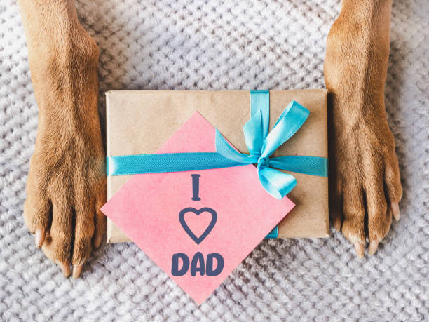 istock Dog paws, gift box and note for Father 2195402443