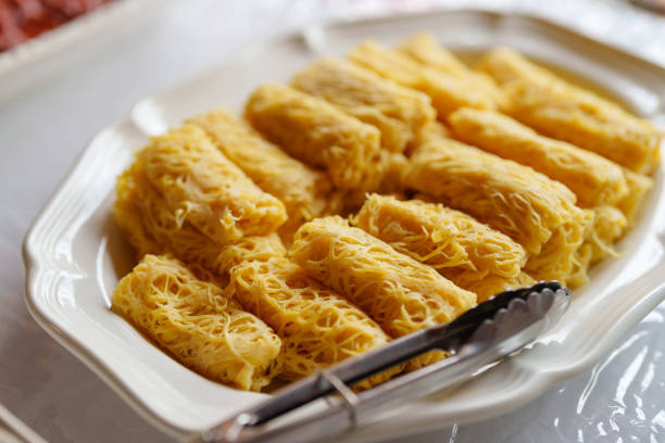 Close-up of traditional Malaysian roti jala, also known as net crepes, neatly arranged on a white plate and ready to be served.