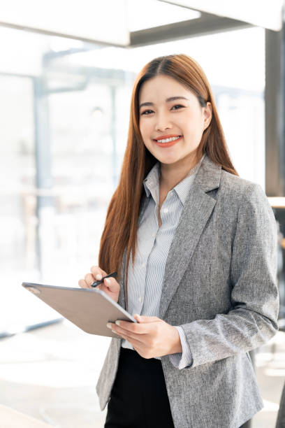 istock Successful business woman using tablet, looking confident and smiling 2195403889