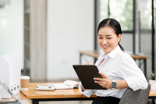 istock Successful business woman looking confident using digital tablet at desk office. 2195404956