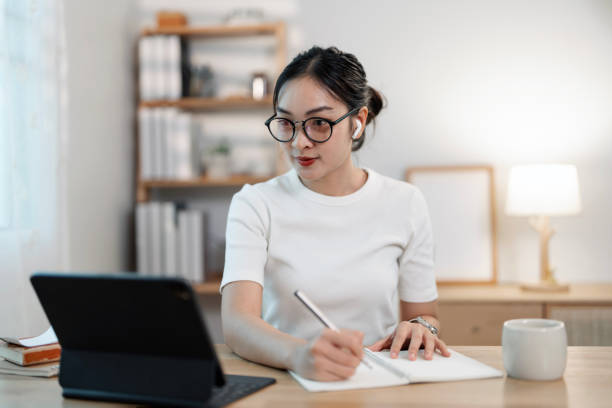 istock happy woman freelancer holding cup while using laptop at home 2195405326